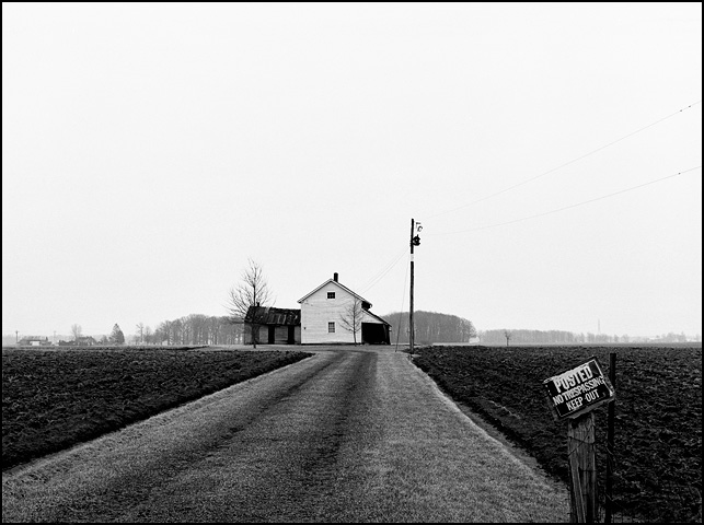 An abandoned farmhouse at the corner of Minnich Road and Monroeville Road near Hoagland, Indiana in Allen County. The house sits in the middle of a plowed field at the end of a long driveway with a no trespassing sign.