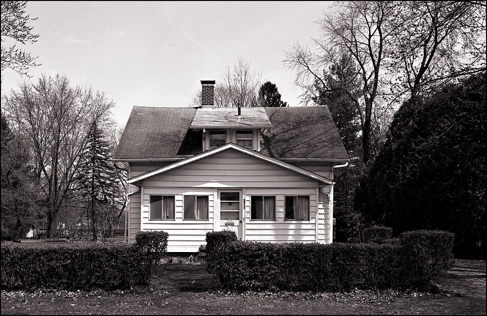 Black and white photograph of a white house in harsh sunlight. The film was developed normally.