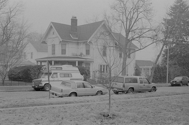 An un-edited scan of a black and white negative scanned with a Nikon LS-8000ED scanner using Vuescan software. Photograph of a white brick house.